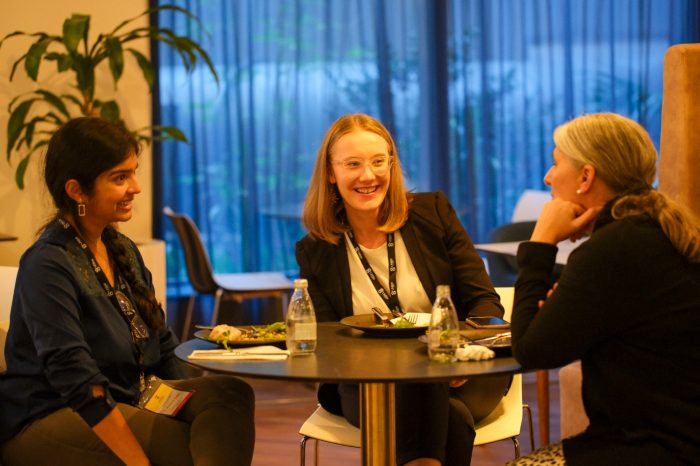 Three women chatting over food.