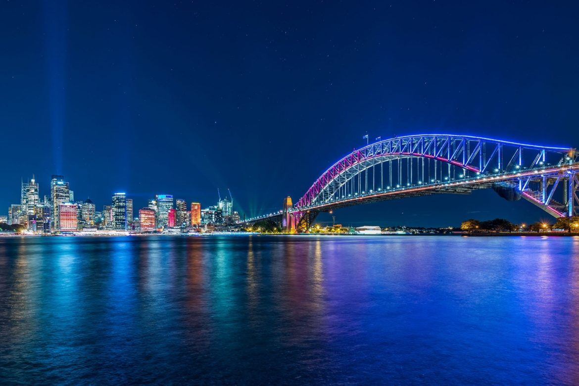 Photo of Sydney city lights, Opera House, and Harbour Bridge at night during Vivid festival