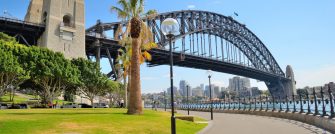 Side view of Sydney Harbour bridge in bright blue sky.
